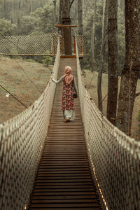 Woman walking on footbridge