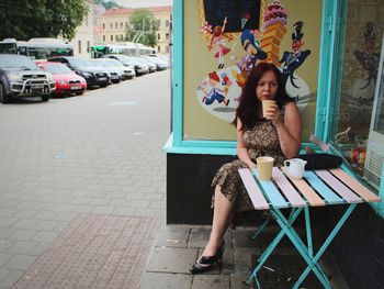 Full length of woman sitting on seat