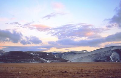 Scenic view of snowcapped mountains against sky during sunset