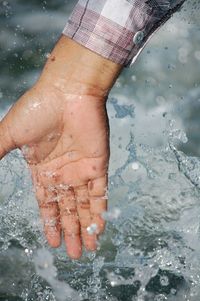 Close-up of hand splashing water