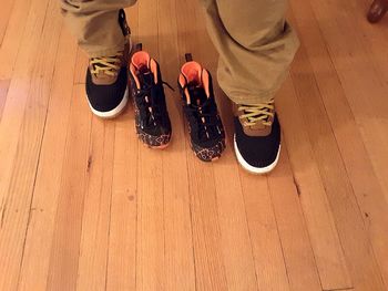 Low section of man standing on hardwood floor