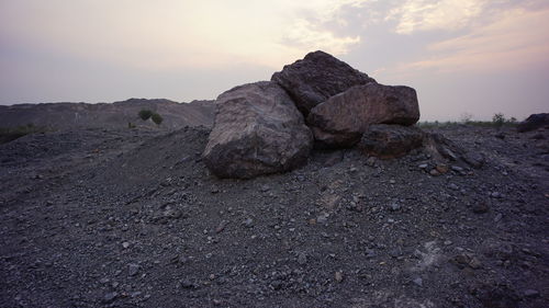 Rock formations on landscape against sky during sunset