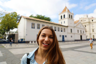 Portrait of a smiling young woman in city