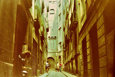 Rear view of narrow alley amidst buildings in city