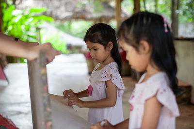 Siblings making paper at workshop