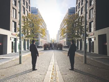 Rear view of man walking on footpath in city