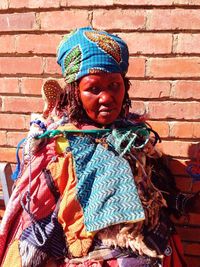 Portrait of tribal woman against brick wall