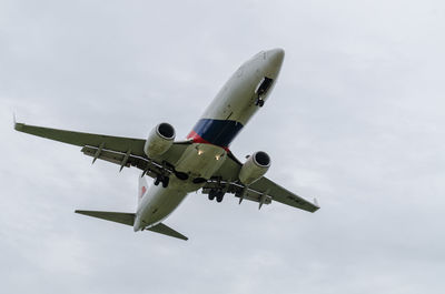 Low angle view of airplane flying against sky