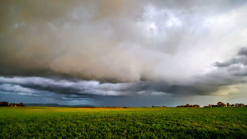 Scenic view of agricultural field against storm clouds