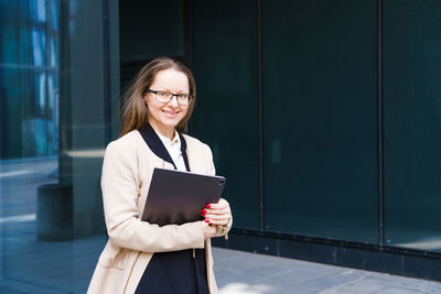 Business woman with folder in hand and glasses near business center