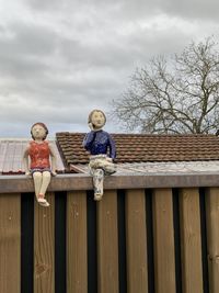 Doll on railing against sky