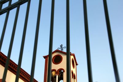 Low angle view of bell tower against clear blue sky