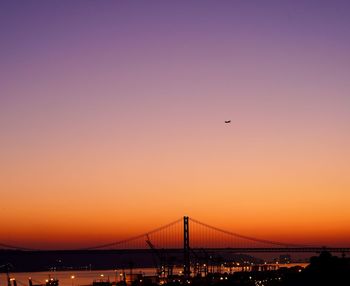 Silhouette of suspension bridge against sky during sunset