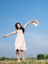 Full length of woman standing on field against sky