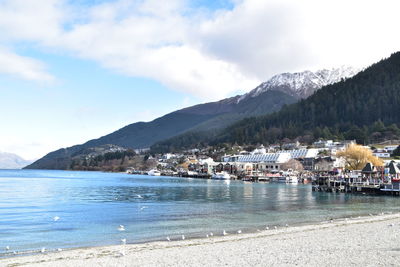 Scenic view of sea by buildings against sky