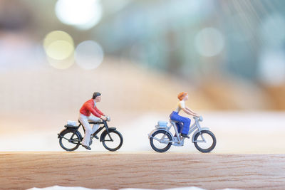 People riding bicycles on toy car