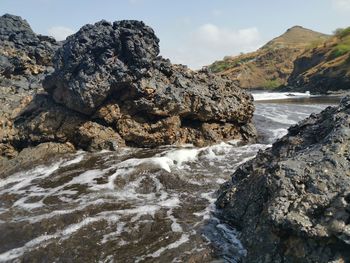 Scenic view of rocks in sea against sky