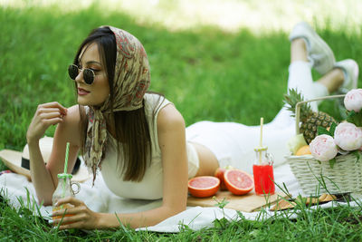 Midsection of woman sitting on field