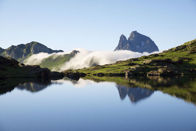 Ossau peak reflected in anayet lake in tena valley, huesca province in aragon, pyrenees in spain.