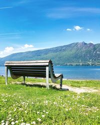 Bench in park against blue sky