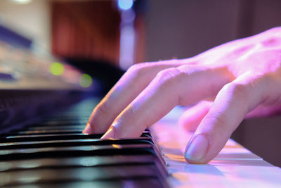 Cropped image of human hand playing piano