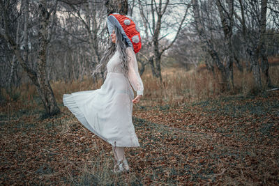 Midsection of woman with umbrella in forest