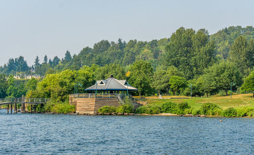 House by lake against sky