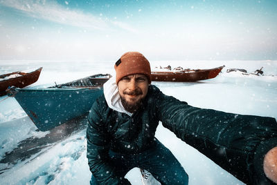 Portrait of young man standing on snow