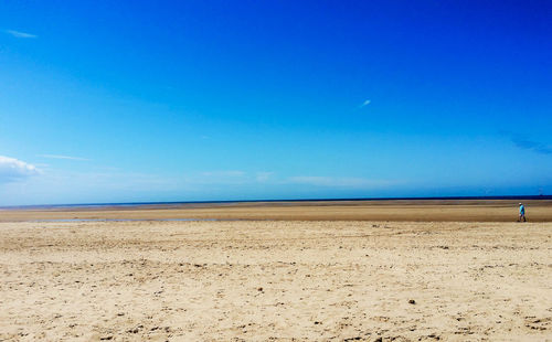 Scenic view of beach against blue sky