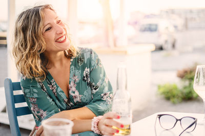 Smiling young woman sitting on table