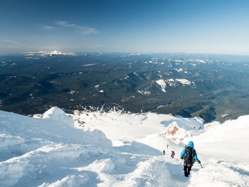 People on snowcapped mountain against sky