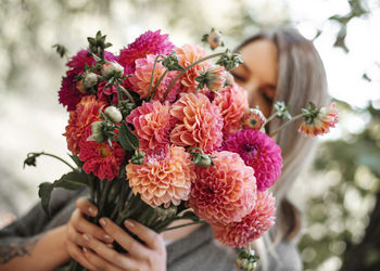 Close-up of woman holding pink flower bouquet