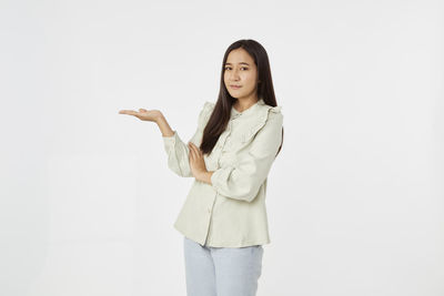 Portrait of smiling young woman against white background