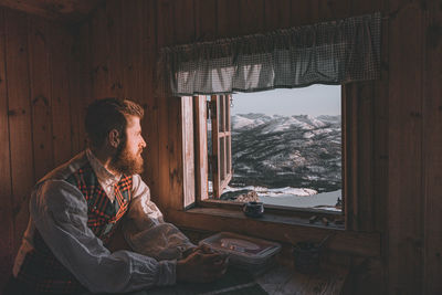 Man sitting by window in snow