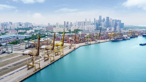 High angle view of buildings by harbor against sky