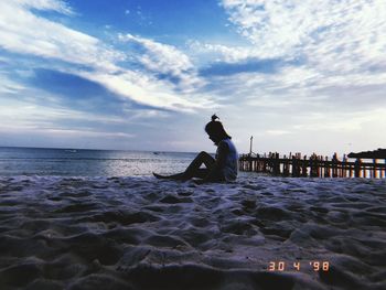 Silhouette man on beach against sky