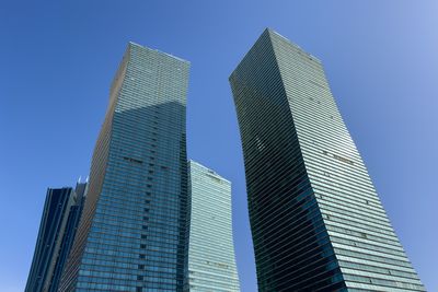 Low angle view of modern building against blue sky