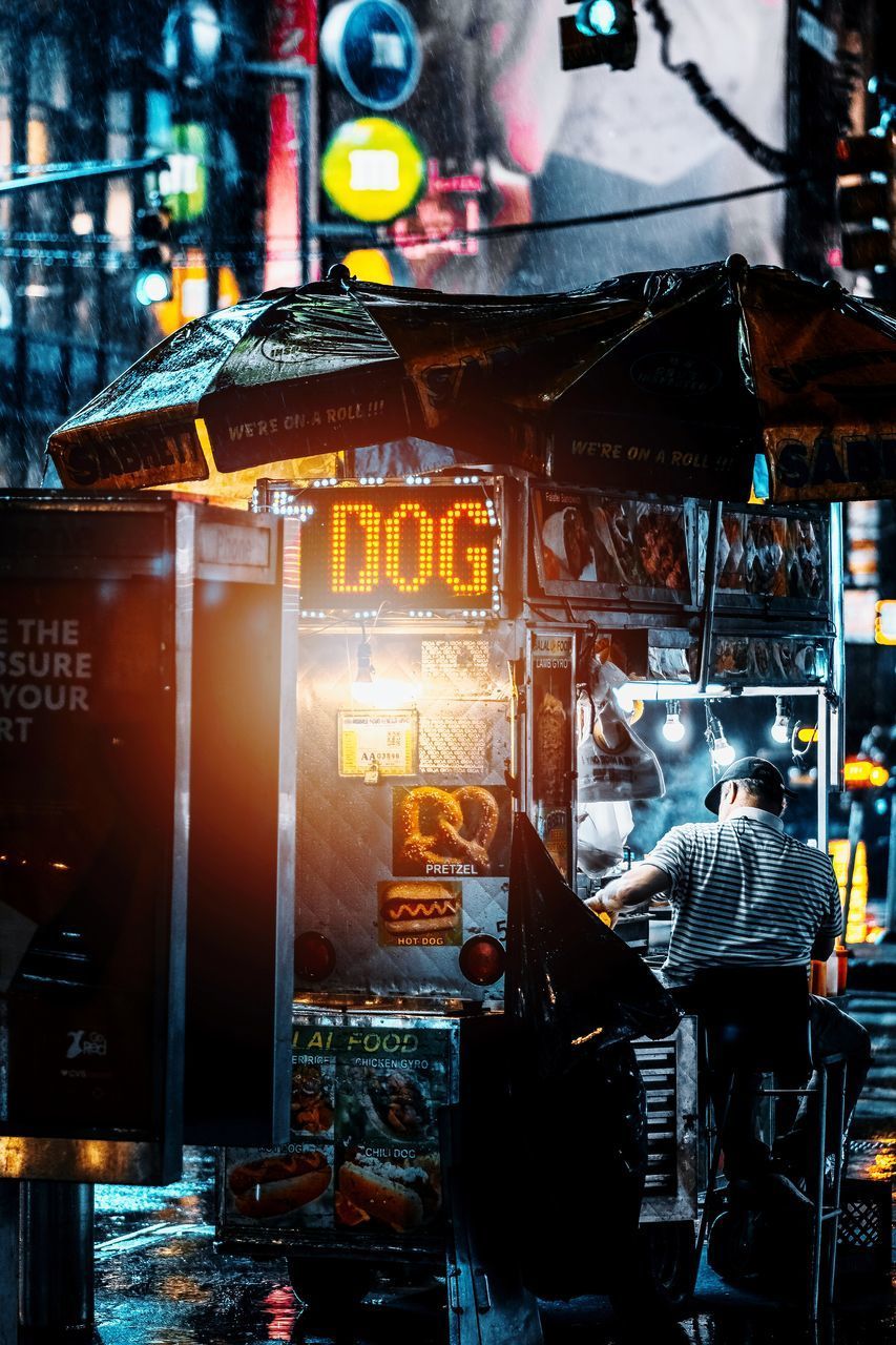 REAR VIEW OF MAN WORKING AT DUSK