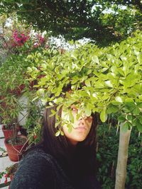 Portrait of young woman with plants in park