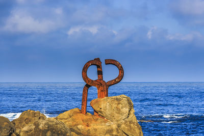 View of rock by sea against sky