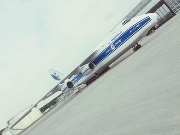 Low angle view of airplane on airport runway against sky