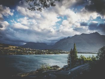 Scenic view of river and mountains against cloudy sky