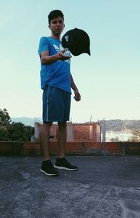 Portrait of happy boy standing against clear sky