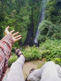 Low section of man by waterfall