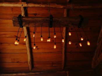 Low angle view of illuminated light bulbs hanging from ceiling