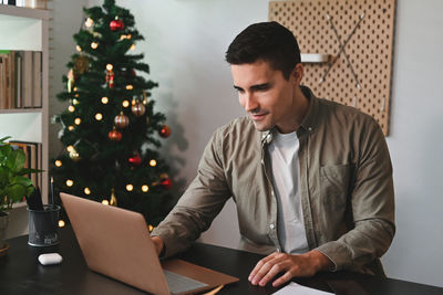 Young man sitting on table at home