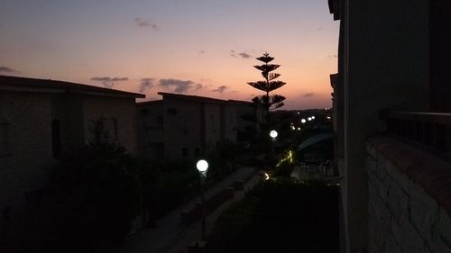 Street amidst buildings against sky at dusk