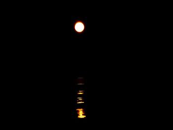 Low angle view of illuminated lighting equipment against sky at night