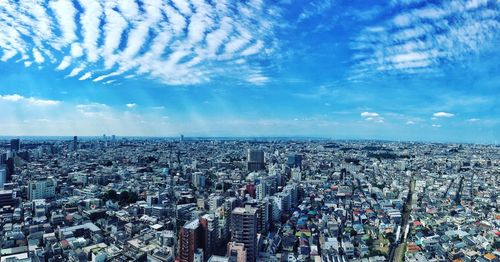 High angle view of modern buildings against cloudy sky