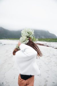 Rear view of woman standing at beach